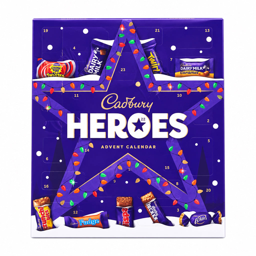Cadbury Heroes Advent Calendar box standing upright on a tiled floor with a blurred store background. The purple box features a large star design, small numbered compartments, and illustrations of assorted chocolates and candy bars.
