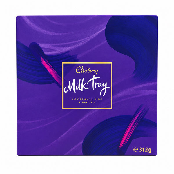 A Cadbury Milk Tray chocolate box in purple packaging, standing on a textured mat on a wooden table with a blurred store background.