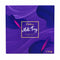 A Cadbury Milk Tray chocolate box in purple packaging, standing on a textured mat on a wooden table with a blurred store background.