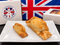 Two golden-brown baked pastries on a white square plate, with a Myers of Keswick branded box and a Union Jack flag in the background.