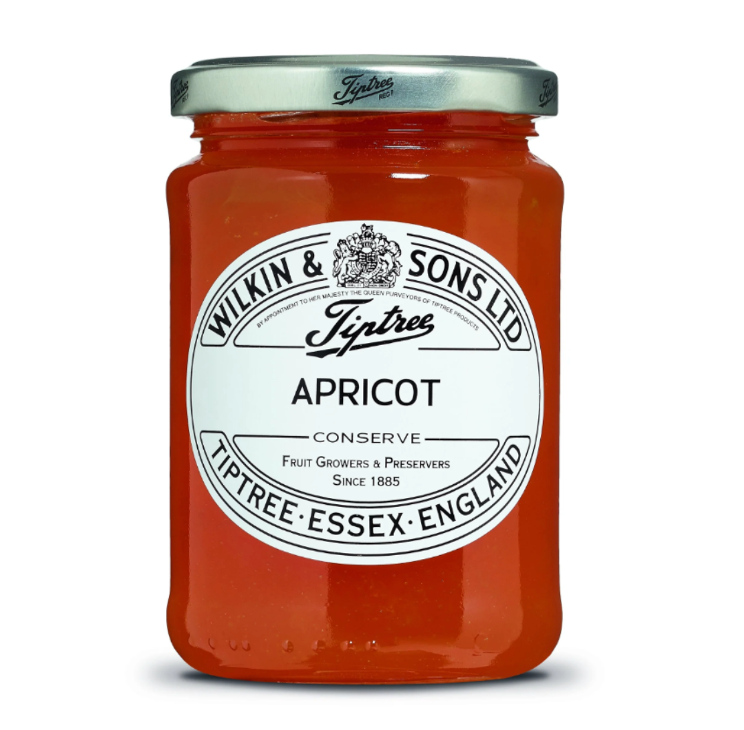 A glass jar of Tiptree Apricot Conserve with a label showing the brand and product name.